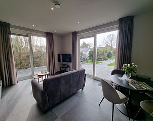 Ruime woonkamer met uitzicht op tuin in Schoonoordsingel 29a, vakantieverblijf Den Burg, Texel.