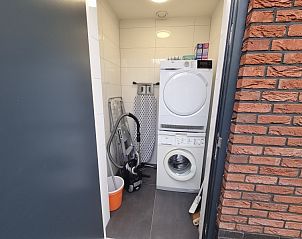 Praktische wasruimte in Schoonoordsingel 29a vakantiewoning, Den Burg, Texel, met wasmachine en droger.