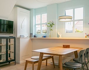 Lichte eetkamer in Stadhuisje Texel, Den Burg, Texel met moderne meubels en ramen die uitzicht bieden op de natuur.