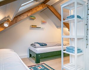 Slaapkamer in Stadhuisje Texel vakantiehuis, Den Burg, Texel met houten balken en comfortabele bedden.