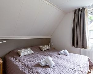 Ruime slaapkamer op bovenverdieping van Huisje in Den Burg, Texel, met veel lichtinval.