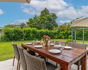 Gezellig terras met uitzicht op de tuin in Huisje in Den Burg, Texel, perfect voor ontspanning.