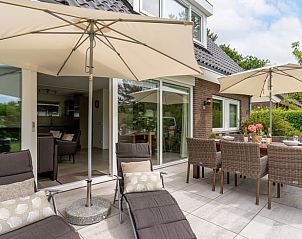 Comfortabele ligstoelen op het terras van Huisje in Den Burg, Texel, voor ultieme ontspanning.