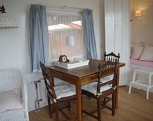 Eethoek in De Bedstee, vakantiehuis Texel, met houten tafel en comfortabele stoelen.
