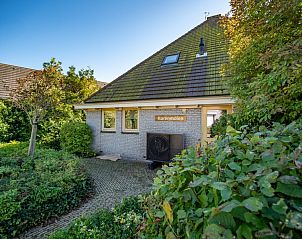 Vooraanzicht van Korenmolen vakantiehuis in Den Burg, Texel met weelderige tuin.