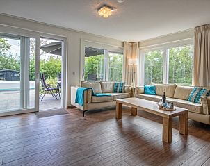 Lichte woonkamer in Villa 3C, Den Burg Texel, vakantiehuis met uitzicht op terras en natuur.