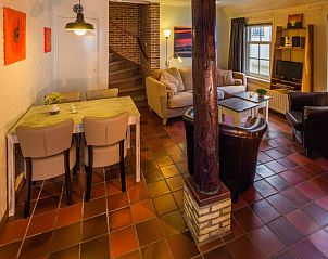 Gezellige woonkamer van Appartement De Kwikstaart, Den Burg, Texel, met comfortabele zitruimte en warme houten accenten.