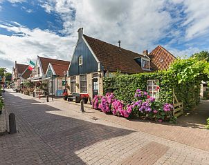 Pittoreske straat in Den Burg, Texel, nabij Appartement De Kwikstaart, met charmante huizen en kleurrijke bloemen.