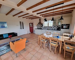 Comfortabele eet- en zithoek in Vakantiehuis Duinzicht, Den Burg, Texel, met rustieke houten balken en veel lichtinval.