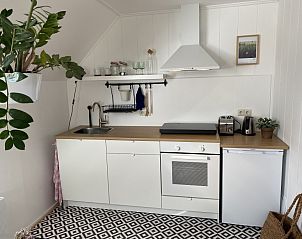 Moderne Kchenzeile im Doppelstudio 4, Den Hoorn, Texel, mit schlichten weien Schrnken und Holzarbeitsplatte.