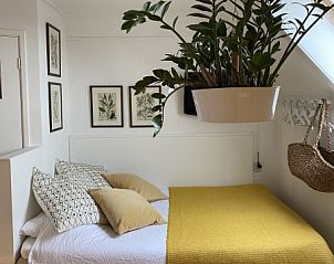 Gemtliches Schlafzimmer im Doppelstudio 4, Den Hoorn, Texel, mit frischem Bettzeug und stilvollen Pflanzen.