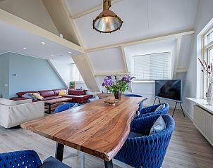 Modernes Wohnzimmer im Hotel Loodsmans Welvaren - Apartment, Den Hoorn, Texel mit gerumiger Sitzecke und Esstisch aus Holz.