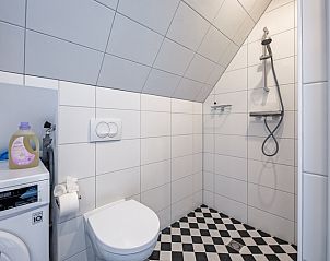 Badezimmer im Hotel Loodsmans Welvaren - Apartment, Den Hoorn, Texel mit Dusche und Waschmaschine.