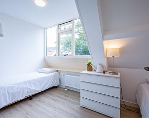 Helles Schlafzimmer mit Einzelbett im Hotel Loodsmans Welvaren - Apartment, Den Hoorn, Texel.