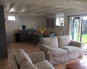 Cozy indoor space of Achterhuis vacation home in Den Hoorn Texel, complete with sitting area and dining area.