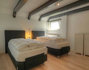 Spacious bedroom with separate beds in Achterhuis vacation home, Den Hoorn Texel, perfect for families.