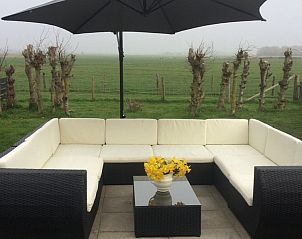 View from the terrace of Achterhuis vacation home Den Hoorn Texel, with comfortable seating area.