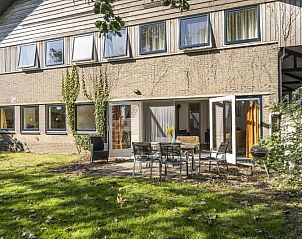 Spacious terrace at vacation home Sil in Den Hoorn, Texel with garden furniture and green surroundings.