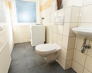Bathroom in vacation home Sil in Den Hoorn, Texel with toilet and washing machine.