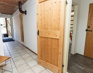 Entrance to vacation home Sil in Den Hoorn, Texel with wooden doors and tiled floor.