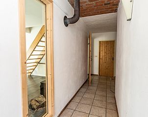 Hallway in vacation home Sil in Den Hoorn, Texel with access to several rooms and wooden details.