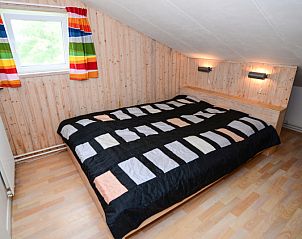 Houten slaapkamer in De Kievit vakantiewoning Den Hoorn Texel met groot bed.