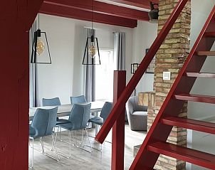 Einzigartiges Treppenhaus und Essbereich im Ferienhaus in Den Hoorn, Texel, mit einer Mischung aus modernen und rustikalen Elementen.