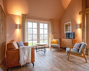 Gemtliches Wohnzimmer des Ferienhauses in Den Hoorn, Texel, mit bequemen Sitzgelegenheiten und Blick auf die Natur der Watteninseln.