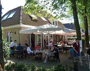 Gasten genieten van de zon op het terras van Hotelsuites Ambrosijn, Schiermonnikoog.