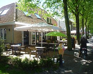Zonnig terras met parasols bij Hotelsuites Ambrosijn, Schiermonnikoog.