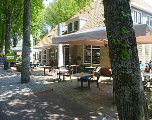 Rustig terras bij Hotelsuites Ambrosijn, Schiermonnikoog, omgeven door groen.