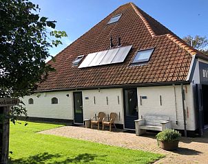 Gemtlicher Innenbereich des Ferienhauses in Oosterend, Texel, mit Essbereich und offener Treppe.