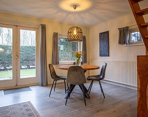 Eethoek in vakantiehuis Nieuwlanderweg 69, De Koog, Texel, met ronde tafel en uitzicht op de tuin voor gezellige maaltijden.