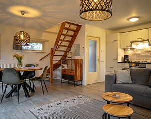 Open keuken en woonkamer in vakantiehuis Nieuwlanderweg 69, De Koog, Texel, met houten trap en sfeervolle inrichting.