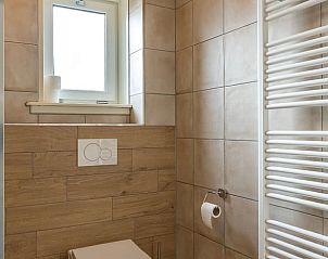 Badkamer in vakantiehuisje in Oosterend Texel met toilet en grote spiegel.