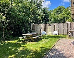 Geniet van de groene tuin bij Vakantiehuis in Oosterend Texel, Waddeneilanden, met picknicktafel en zitjes.