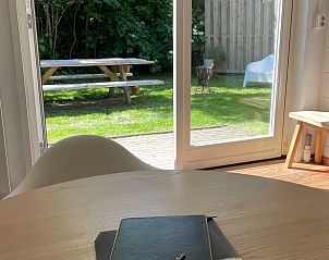 Uitzicht vanuit de eetkamer van Vakantiehuis in Oosterend Texel, met toegang tot de tuin.