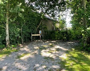 Parkeerplaats omgeven door groen bij Vakantiehuis in Oosterend Texel, Waddeneilanden.