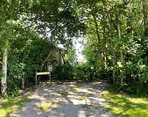 Ingang met parkeerplaats bij Vakantiehuis in Oosterend Texel, omgeven door natuur.