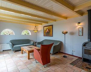 Gezellige woonkamer in Vakantiehuis Oosterend Texel met comfortabele zitplaatsen en een houtkachel, ideaal voor ontspanning.