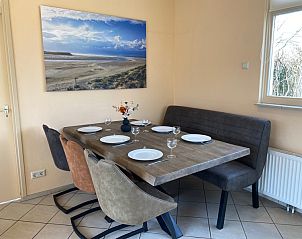 Dining area of vacation home Noordzee in Oosterend, Texel overlooking nature.