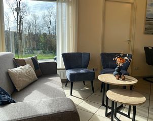 Stylish sitting area in vacation home Noordzee in Oosterend, Texel overlooking the greenery.