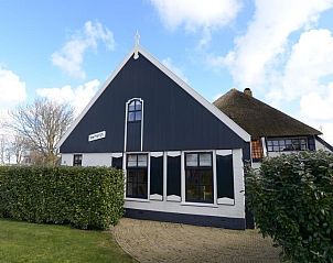 Voorzijde van Gouden Rijder vakantiehuis in Oosterend, Texel, met traditionele architectuur en groene heg.
