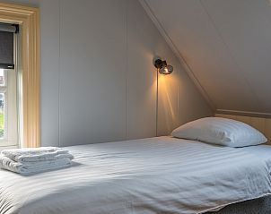 Gezellige slaapkamer in Gouden Rijder vakantiehuis, Oosterend, Texel, met uitzicht op de tuin.