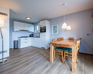 Eetruimte met houten tafel in vakantiehuis Type II - nr. 43 Stormvogel, Oosterend, Texel naast moderne keuken.