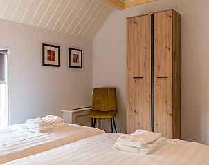 Slaapkamer met tweepersoonsbed in 13 - Dukaat - allotment, vakantiehuis Oosterend, Texel, met houten kast.