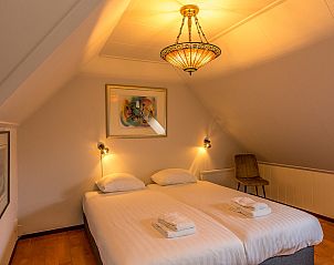 Knusse slaapkamer met dakraam in 13 - Dukaat - allotment, vakantiehuis Oosterend, Texel, voor natuurlijke lichtinval.