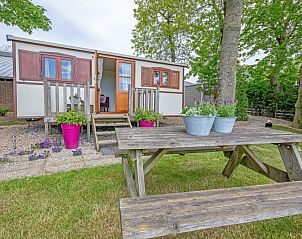 Geniet van de rust bij Pipowagen De Vrije Vogel in Oudeschild, Texel, met een charmante veranda en groene omgeving voor een unieke vakantie-ervaring.