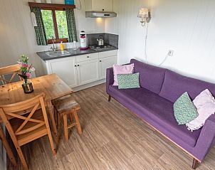 Gezellige binnenruimte van Pipowagen De Vrije Vogel in Oudeschild, Texel met knusse zithoek en keuken voor een ontspannen verblijf.