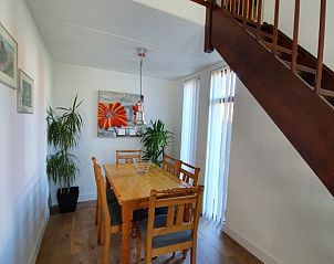 Eetgedeelte in Alkema bungalowverhuur Gortersmient, Texel, met houten tafel en stoelen.